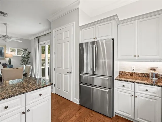 a kitchen with granite countertop stainless steel appliances a refrigerator and cabinets