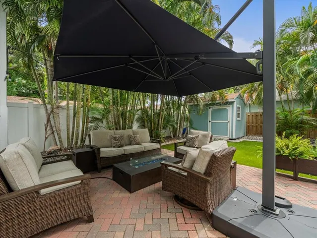 a patio with patio couch and table under an umbrella