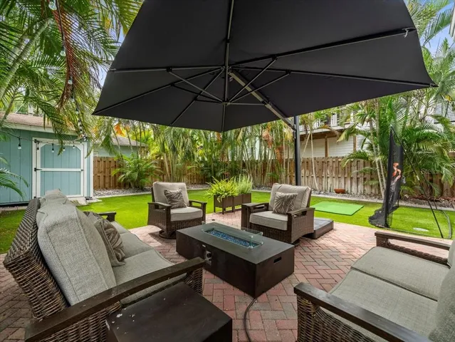 a view of a patio with couches chairs under an umbrella