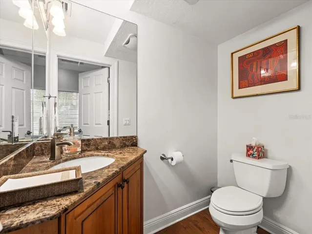 a bathroom with a granite countertop toilet sink and mirror