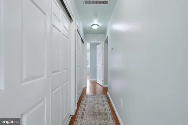 a view of a hallway with wooden floor