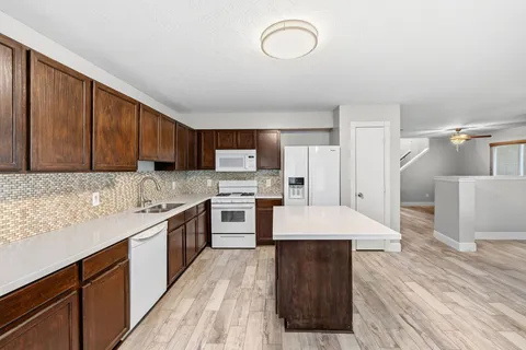 a view of a room with wooden floor and a ceiling fan