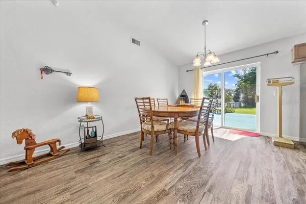 a dining room with furniture a chandelier and wooden floor