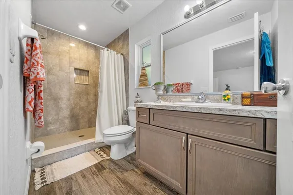 a bathroom with a sink a toilet and shower