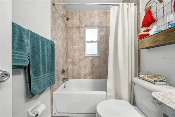a bathroom with a toilet a sink and shower