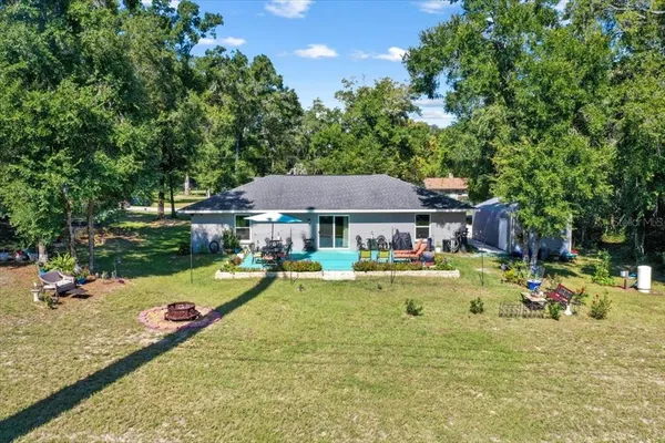 a view of a swimming pool with a patio and a yard