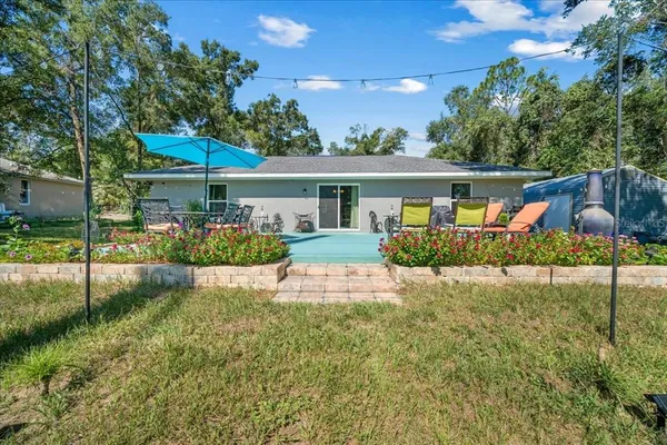 a view of a house with backyard and sitting area