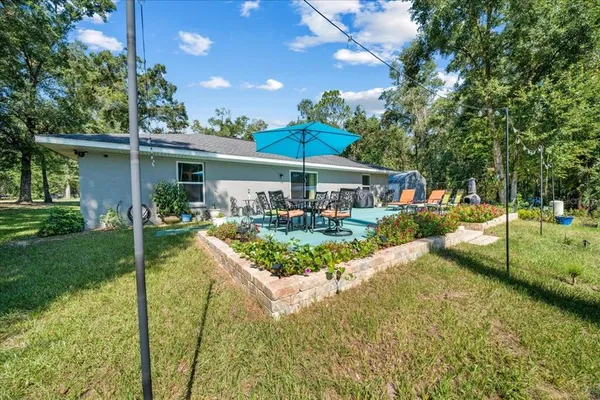 a view of a house with backyard and sitting area