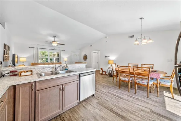 a kitchen with a dining table chairs sink and cabinets