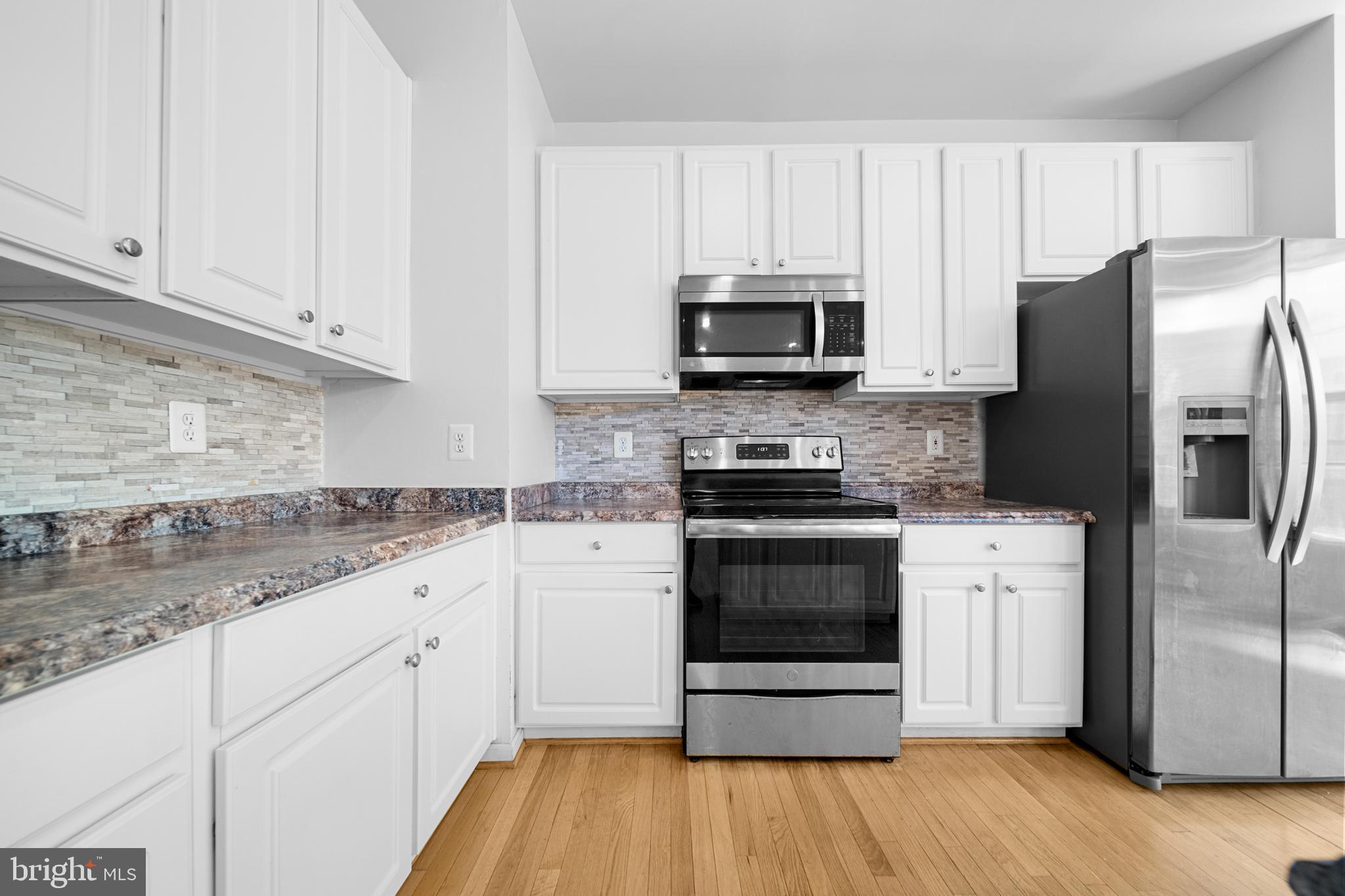 2631 Tarleton Corner Drive Herndon, VA 20171 - Photo 11 of 41 a kitchen with white cabinets stainless steel appliances and a sink