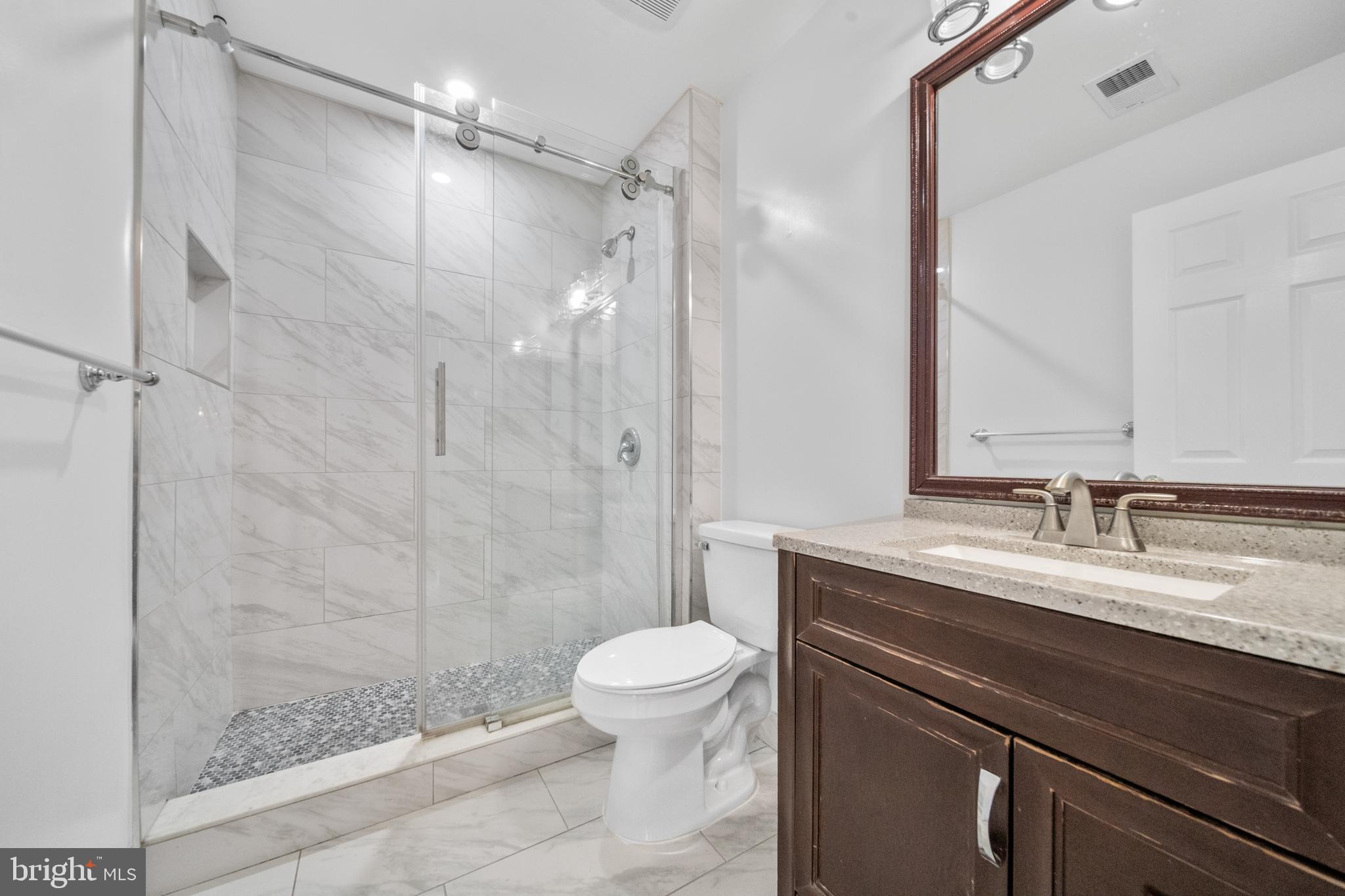 2631 Tarleton Corner Drive Herndon, VA 20171 - Photo 23 of 41 a bathroom with a granite countertop sink toilet a mirror and shower