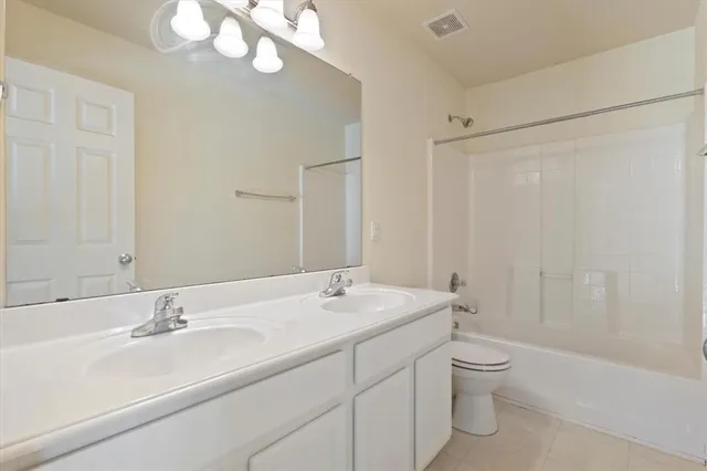 a bathroom with a double vanity sink mirror and toilet