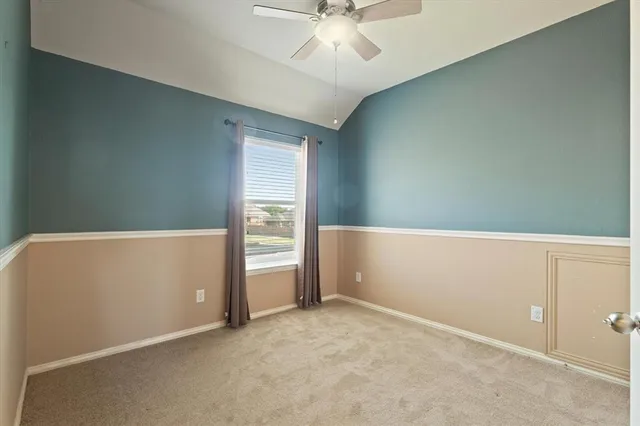 an empty room with cabinet and ceiling fan
