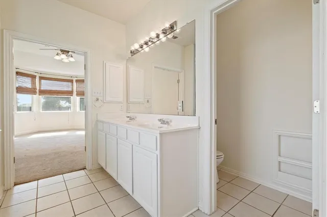 a bathroom with a sink a toilet and large mirror