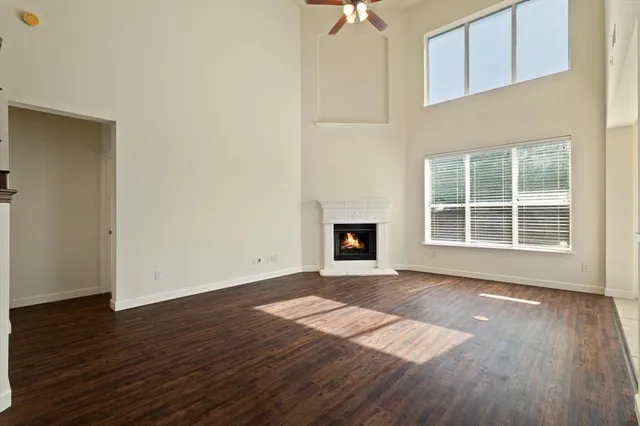 an empty room with wooden floor and fireplace