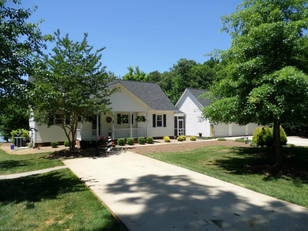 1880 Beckner Road Lexington, NC 27292 - Photo 3 of 30 Street view of the house with a rocking chair front porch, 3 car garage and 2 car or boat carport. House and garage have an architectural roof installed in 2011.