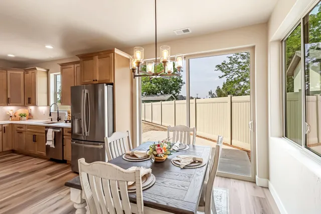 a kitchen with stainless steel appliances granite countertop a refrigerator a oven a kitchen island and chairs in it