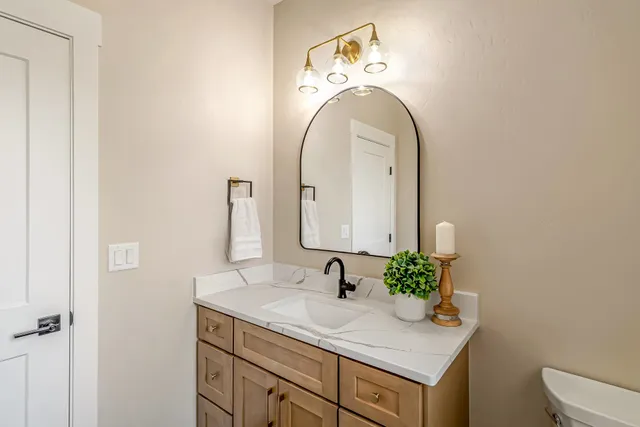 a bathroom with a granite countertop sink and a mirror
