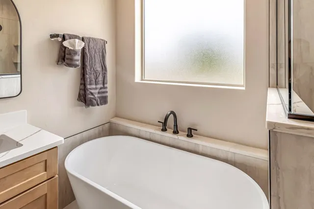 a bathroom with a sink and mirror with window