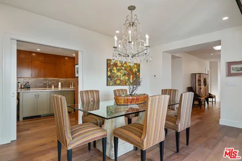 a dining room with furniture a chandelier and wooden floor