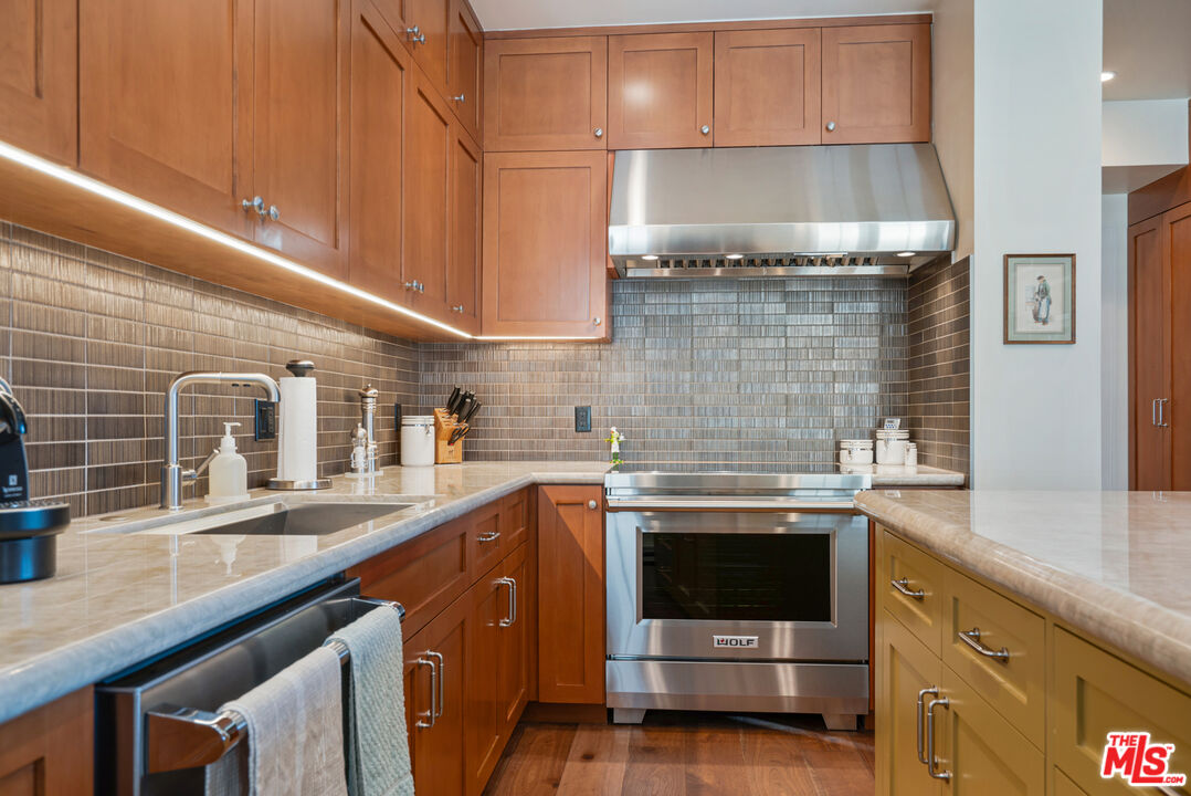 10580 Wilshire Boulevard, Unit 23NE Los Angeles, CA 90024 - Photo 19 of 42 a kitchen with stainless steel appliances granite countertop a sink stove and cabinets