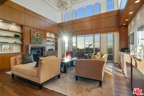 a living room with furniture a fireplace and a chandelier
