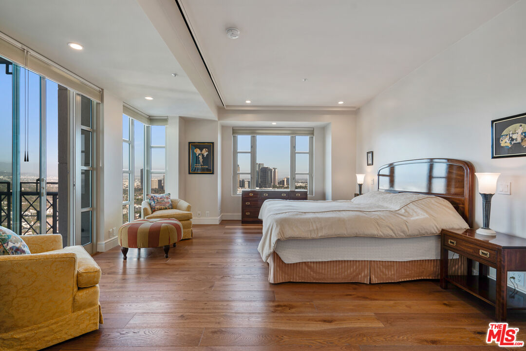 10580 Wilshire Boulevard, Unit 23NE Los Angeles, CA 90024 - Photo 21 of 42 a spacious bedroom with a bed a couch and a large window