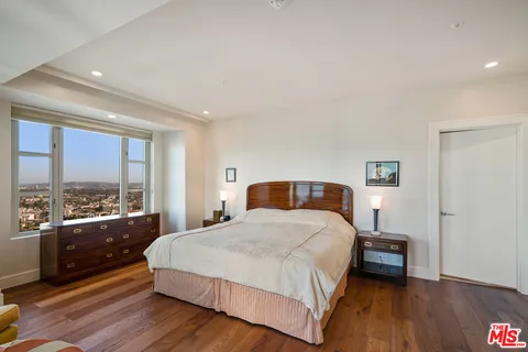 a bedroom with a bed and a large window