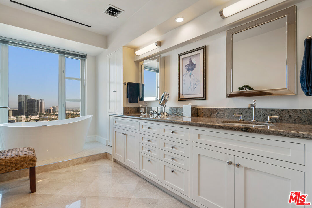 10580 Wilshire Boulevard, Unit 23NE Los Angeles, CA 90024 - Photo 23 of 42 a bathroom with double sink and a mirror