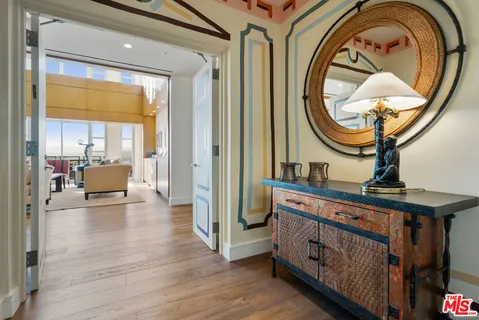 a living room with furniture a mirror and a wooden floor