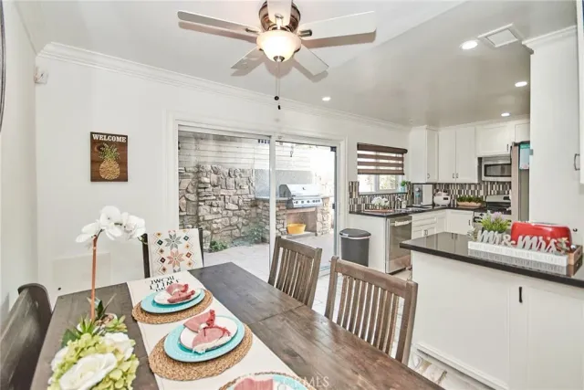 a kitchen with stainless steel appliances wooden floor dining table and chairs