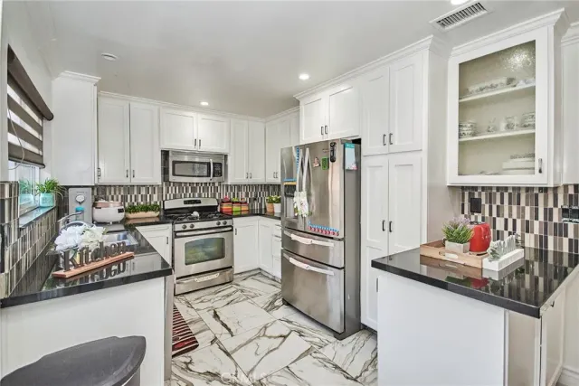 a kitchen with stainless steel appliances granite countertop a refrigerator sink and stove