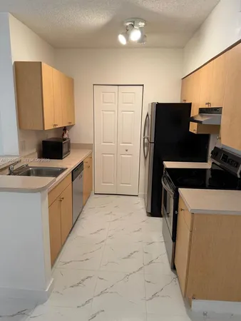 a kitchen with a refrigerator and a stove