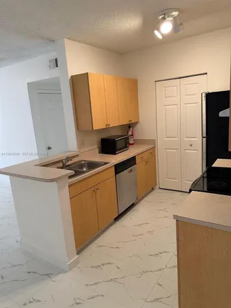 a kitchen with stainless steel appliances a stove a microwave a sink and a refrigerator