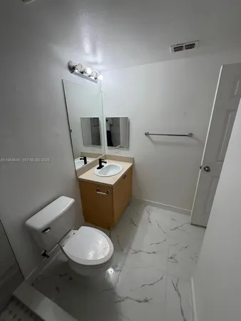 a white toilet sitting next to a bathroom sink