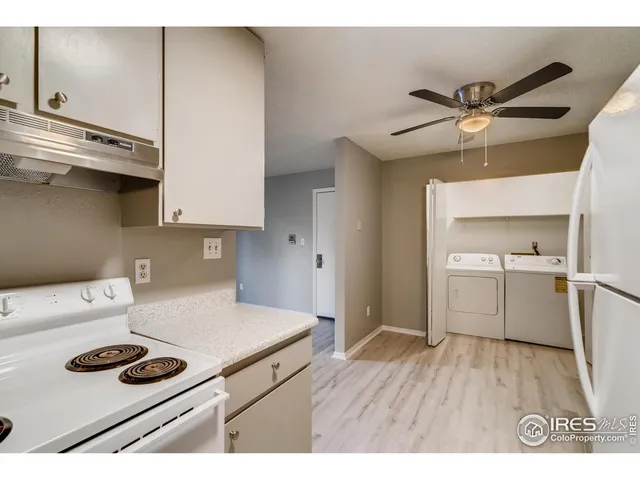 a kitchen with a refrigerator and a stove top oven