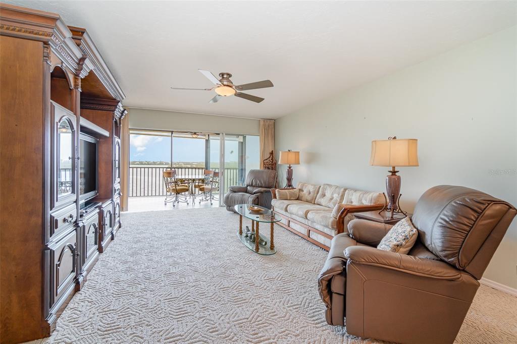 9011 Midnight Pass Road, Unit 329 Sarasota, FL 34242 - Photo 16 of 39 a living room with furniture a ceiling fan and a window