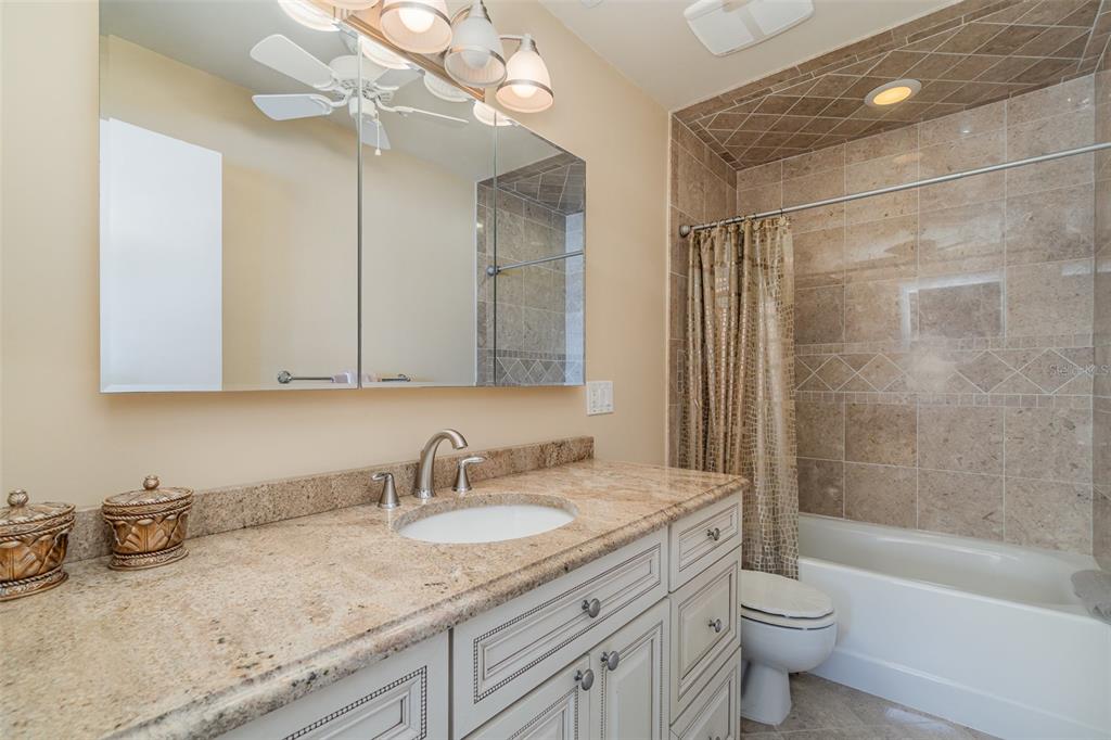 9011 Midnight Pass Road, Unit 329 Sarasota, FL 34242 - Photo 26 of 39 a bathroom with a granite countertop sink a toilet and bathtub