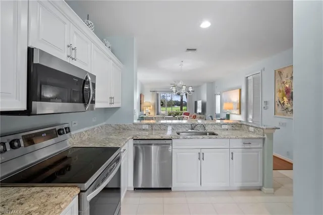 a bedroom with a bed a chandelier and a mirror