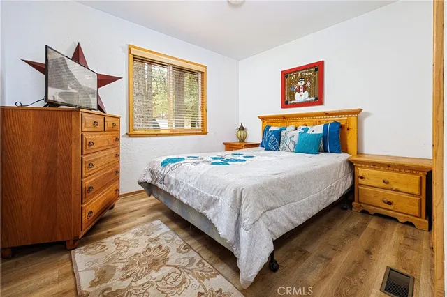 a bedroom with a bed and a dresser next to a window