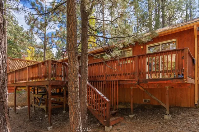 a view of a backyard with wooden fence and large trees