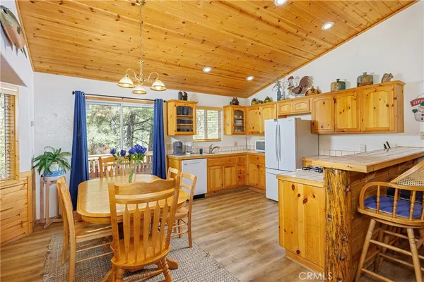 a dining room with furniture a kitchen wooden floor and a window