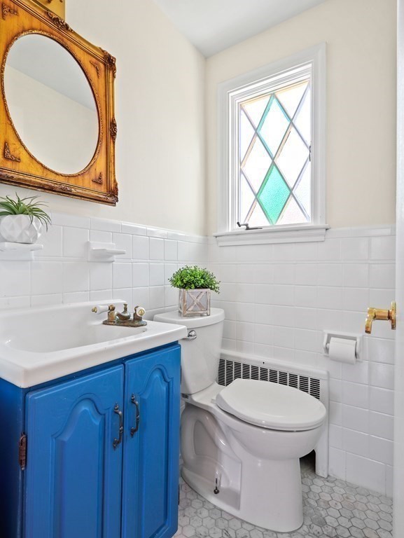 93 Meadowbrook Road Needham, MA 02492 - Photo 14 of 34 a bathroom with a toilet a sink a mirror and next to a window