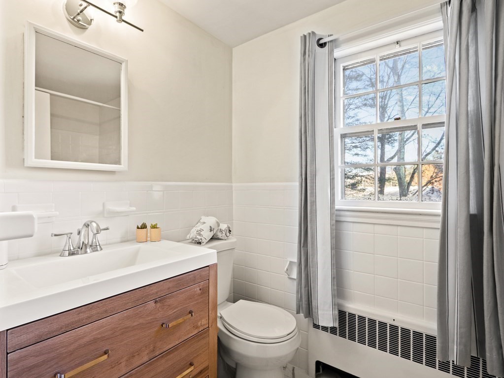93 Meadowbrook Road Needham, MA 02492 - Photo 21 of 34 a bathroom with a sink a mirror and a toilet
