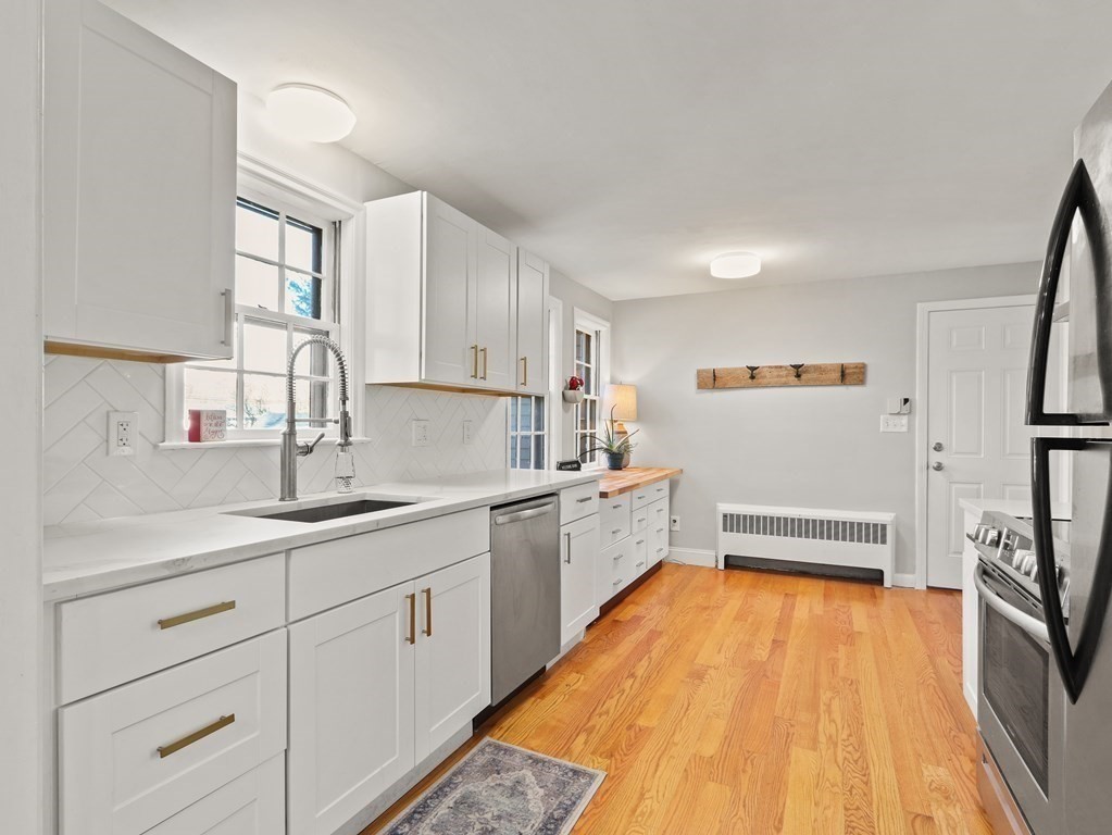 93 Meadowbrook Road Needham, MA 02492 - Photo 5 of 34 a kitchen with a sink and wooden cabinets