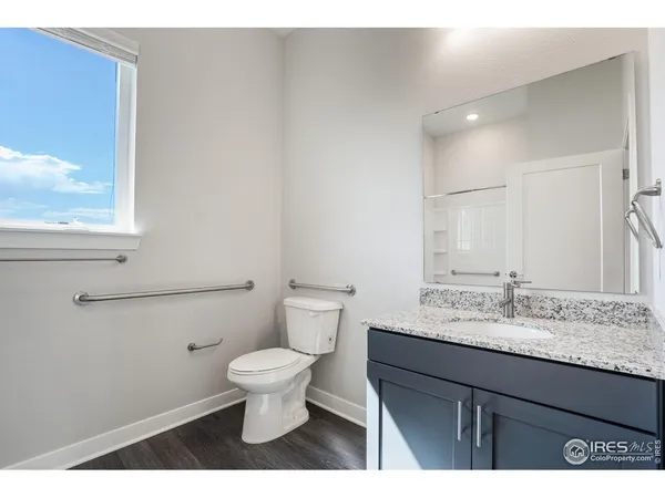 a bathroom with a granite countertop sink a toilet and a mirror