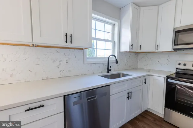 a kitchen with white cabinets and a sink