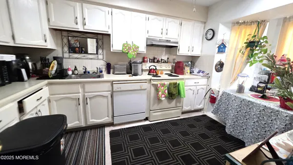 a utility room with stainless steel appliances a stove a sink and a refrigerator