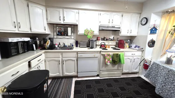 a kitchen with a white stove top oven and cabinets