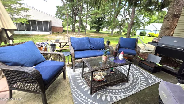 a view of a patio with couches chairs and a yard